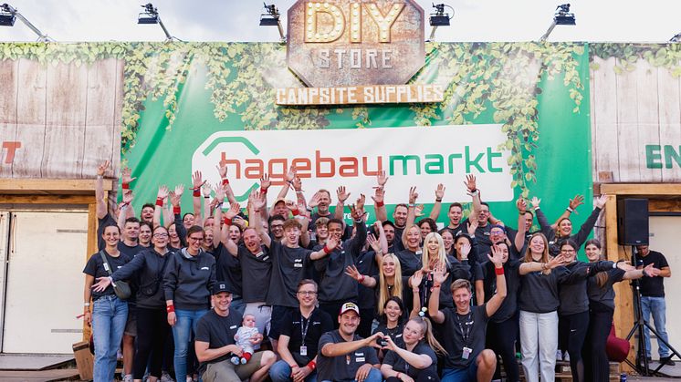 Das 61 köpfige hagebau Team vor dem hagebaumarkt DIY-Store by Swertz auf der Campsite bei dem Parookaville Festival 2025