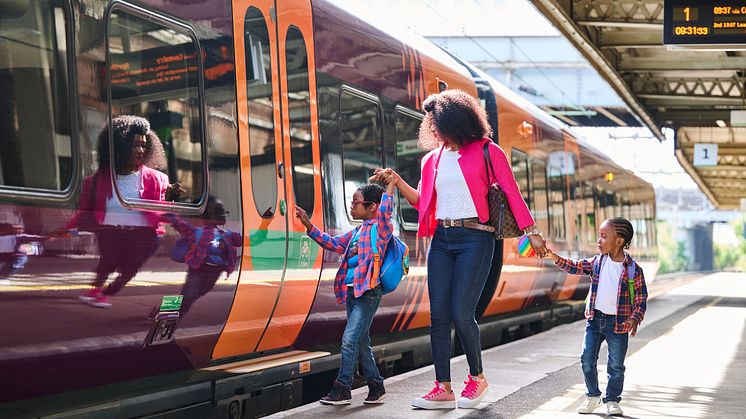 Woman with two young kids boarding a West Midlands Railway train