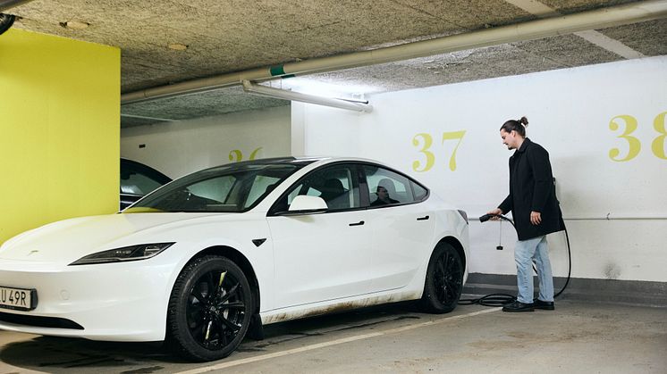 Man som laddar sin elbil i bostadsrättsföreningens garage.