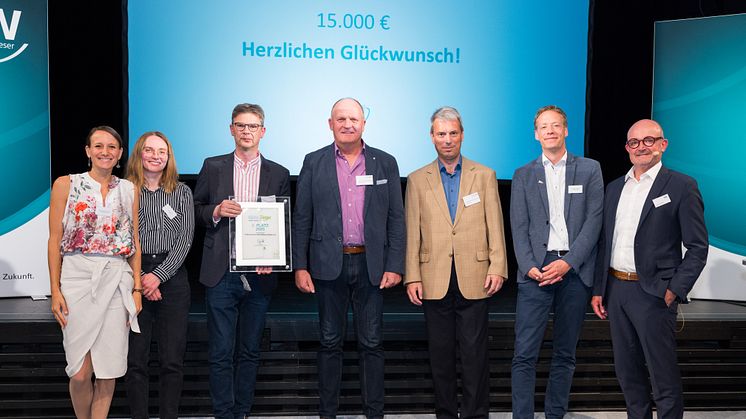Die Jury-Mitglieder Andreas Speith (rechts) und Carolin Wicke (2. v. l.), Bürgermeister von Altenbeken Matthias Möllers (4 v. l.) sowie Anja Lippmann-Krüger (links), Klimaschutzagentur Weserbergland gratulieren dem Trägerverein Heimathaus Buke
