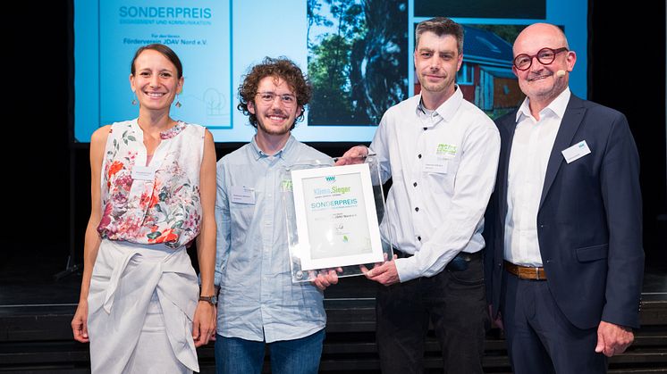 Jurymitglied Andreas Speith (rechts) sowie Anja Lippmann-Krüger (links), Klimaschutzagentur Weserbergland gratulieren den Mitgliedern des Fördervereins JDAV Nord zum Sonderpreis Engagement und Kommunikation