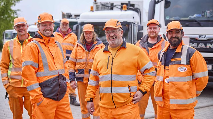 Auf dem Bild sind verschiedene männliche Mitarbeiter von Veolia zu sehen. Sie lächeln zuversichtlich in die Kamera.