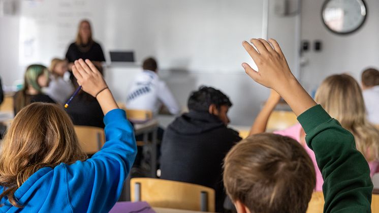 Elever som räcker upp handen i ett klassrum på Internationella Engelska Skolan. 