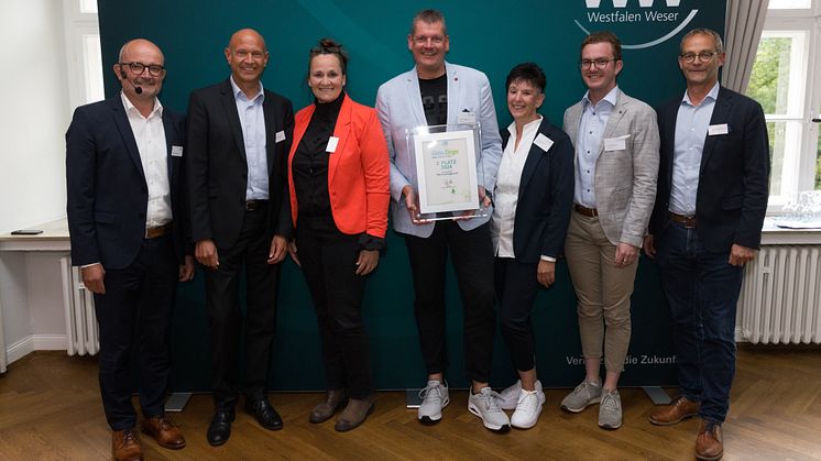 Jury-Mitglieder Andreas Speith (links) und Heinz-Jörg Heinemann (rechts) sowie Daniel Milbrandt von der Klimaschutzagentur (2. v. l.) und die Bürgermeisterin von Obernkirchen Dörte Worm-Kressin (3. v. l.) gratulieren dem TSV Krainhagen.