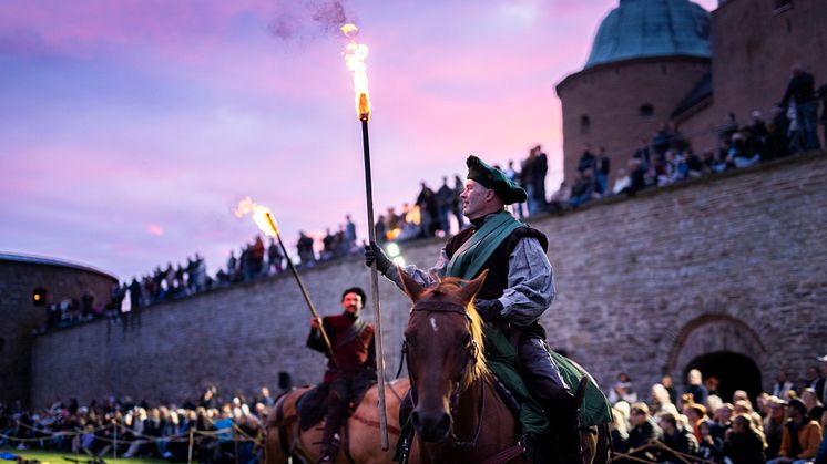 Två riddare till häst står framför en stor publik vid Kalmar Slott.