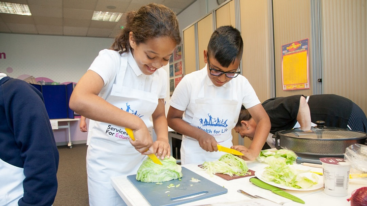 Children chopping vegetables at Health for Life event