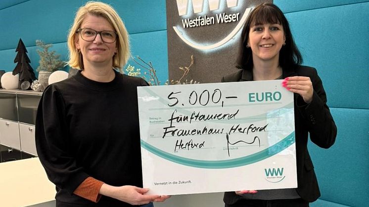 Nadine Heinen (links), Traumapädagogin beim Frauenhaus Herford, nimmt die Spende von Christiane Rüsel (rechts), Kommunalreferentin bei Westfalen Weser, entgegen.