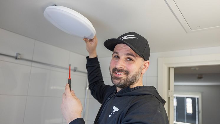 Emil Lidström, en av grundarna till Två Ström AB, installerar armaturen Pop från Lit by Cardi.
