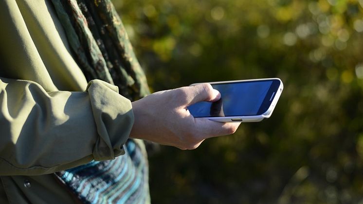hand som håller i en mobiltelefon