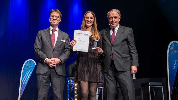 IHK-Hauptgeschäftsführer Dr. Thilo Pahl (l.) und IHK-Präsident Walter Viegener (r.) der IHK Siegen zeichneten Julia Lang von alltours als NRW-Prüfungsbeste bei den Tourismuskaufleuten aus.