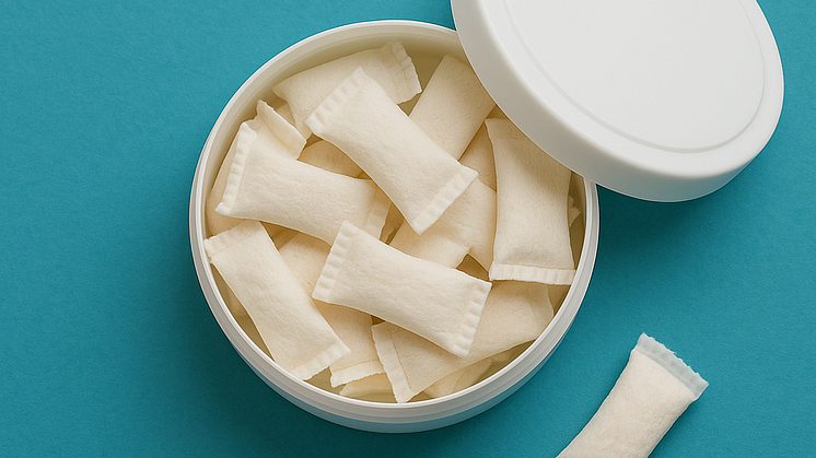 A clean, minimalistic blog header image showing a round open container of nicotine pouches on a turquoise background.