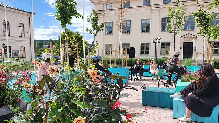 Sommartorget i Härnösand med turkosa sittkuber och vackra färgglada blomsterarrangemang. 