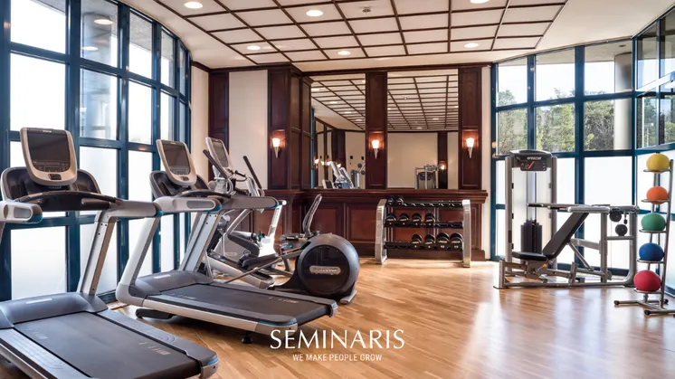 Fitnessraum eines Hotels mit Cardiogeräten, Freihanteln, und weiterem Sportzubehör.