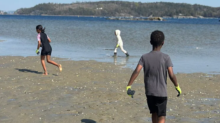 Bilden visar barn som är på en strand.