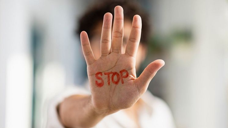 A raised hand with the word 'stop' written on it