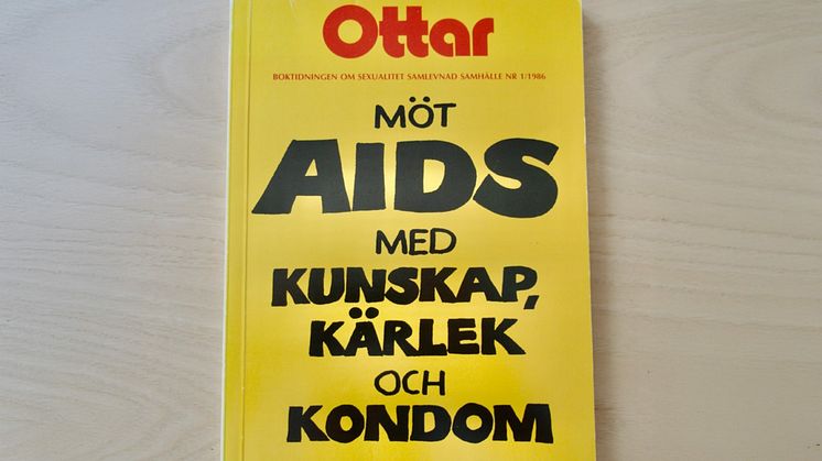 En gul tidskrift med texten "Möt aids med kunskap, kärlek och kondom". 