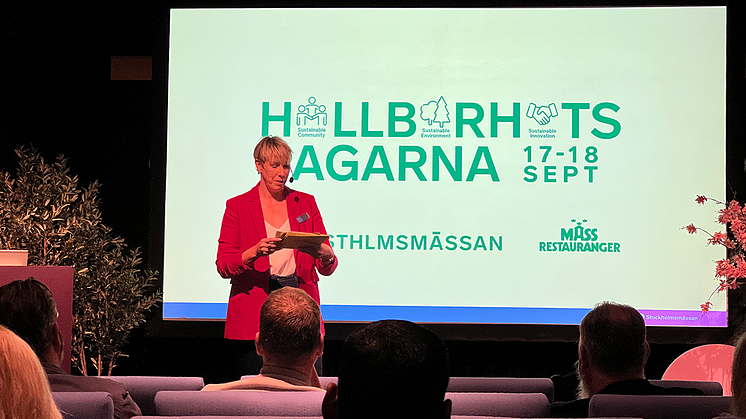 Person står på scen och modererar Hållbarhetsdagarna 2024. 