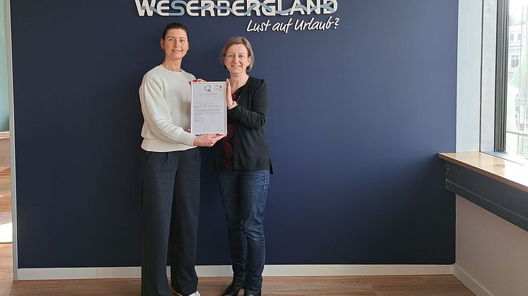 Dorina Brunke und Jessica Dolle vom Weserbergland Tourismus e.V. präsentieren die aktuelle Auszeichnung mit dem Zertifikat "ServiceQualität Deutschland"