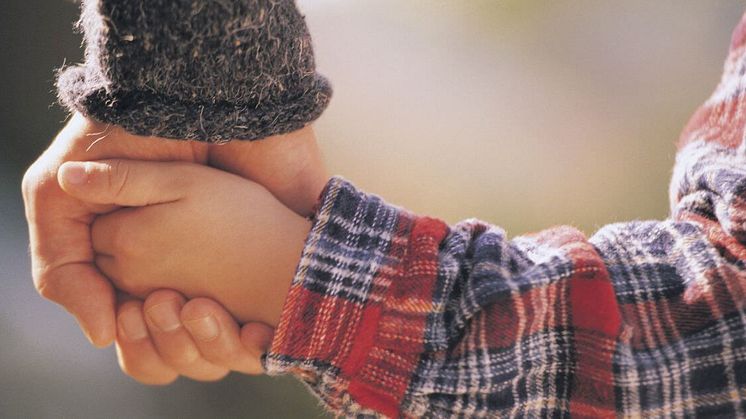 Två händer håller varandra i en trygg gest – stöd och närhet är viktiga för att bygga självkänsla hos barn med NPF.