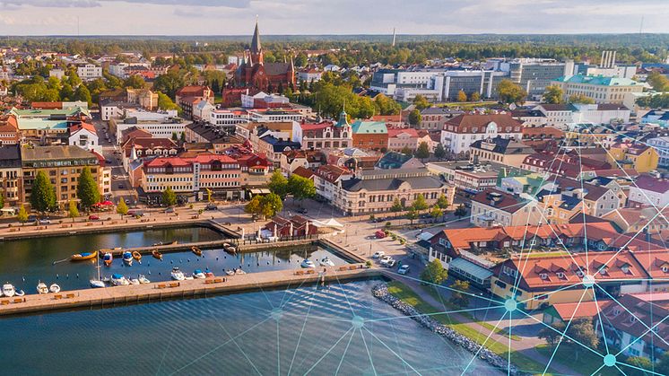 En helikopterbild av Västervik med grafiska element som visar blå punkter sammankopplade med streck.