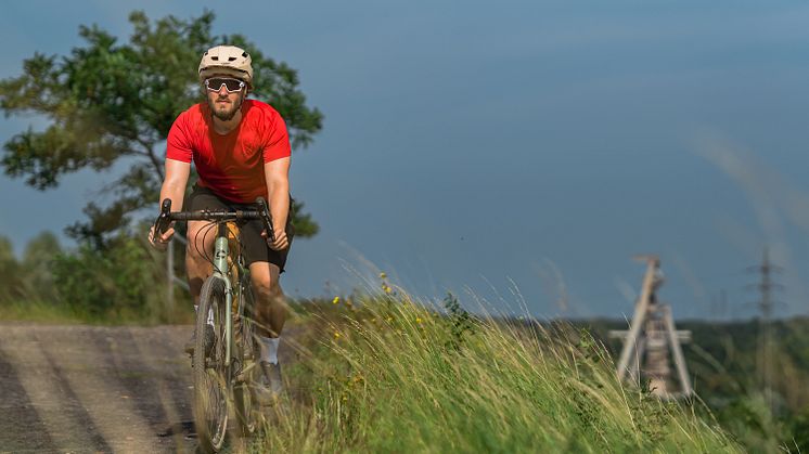 Mann auf Fahrrad, Gravelbike, auf einer Halde im Ruhrgebiet.