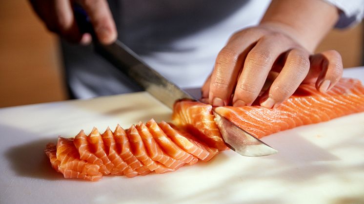Kokk skjærer opp sashimi av norsk laks
