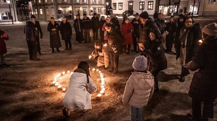 Människor samlade för att tända ljus på Piteå torg i samband med en tidigare minnesdag. Foto: Fond och Fond