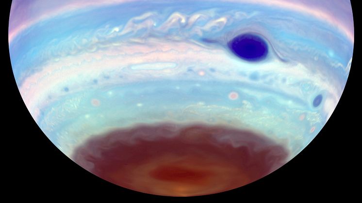 An artificially colored view of Jupiter observed in ultraviolet light. In addition to the Great Red Spot, which appears blue, another oval feature can be seen in the brown haze at Jupiter's south pole.