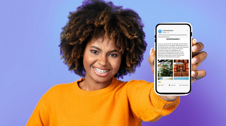 Junge Frau hält Handy zum Betrachter, zu sehen ist Handy-Bildschirm mit Inhalten des digitalen Reisebegleiters, dem Fanguide.