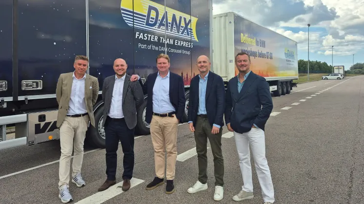Five DANX and BMW Northern Europe representatives in front of branded DANX vehicles at the Staffanstorp distribution centre.