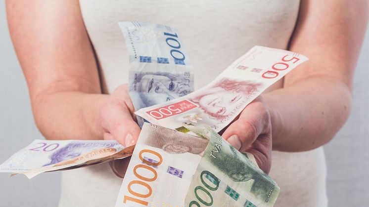 Kvinna håller sedlar i sina händer