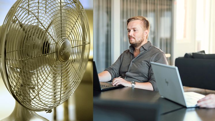 Anställd man använder laptop på kontor, en fläkt 