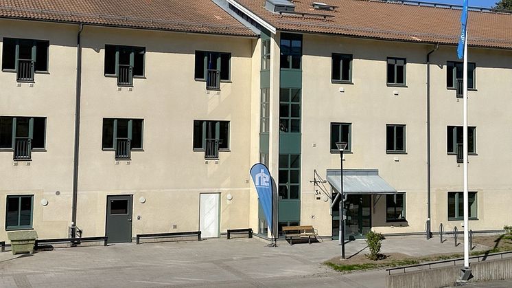 En stor byggnad med en flaggstång framför sig.