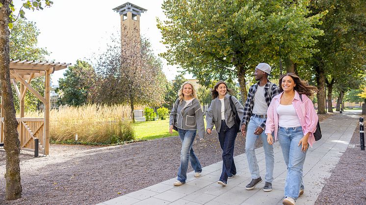 Fyra studenter på promenad på campus på Högskolan i Skövde. 