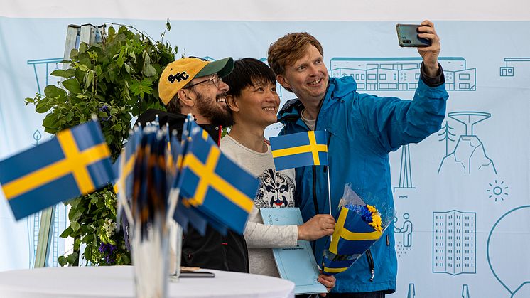 Den nyblivne medborgaren Wei Sun (i mitten) tar en bild med sina vänner under 2024 års medborgarskapsceremoni. Foto: Julia Åhall