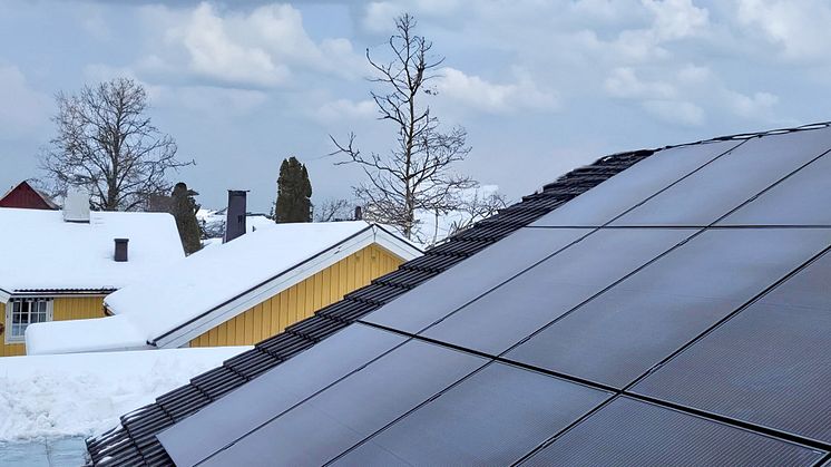 Solceller på ett villatak i en vintermiljö.