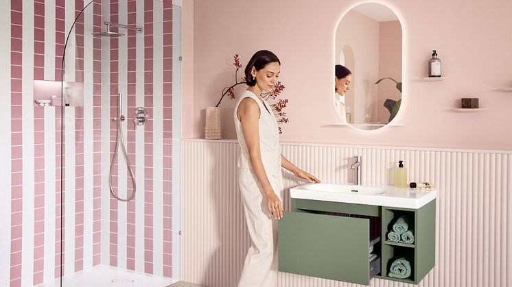Eine Frau ist in ihrem Lifestyle-Badezimmer von Villeroy & Boch zu sehen und öffnet die Schublade vom Unterschrank.