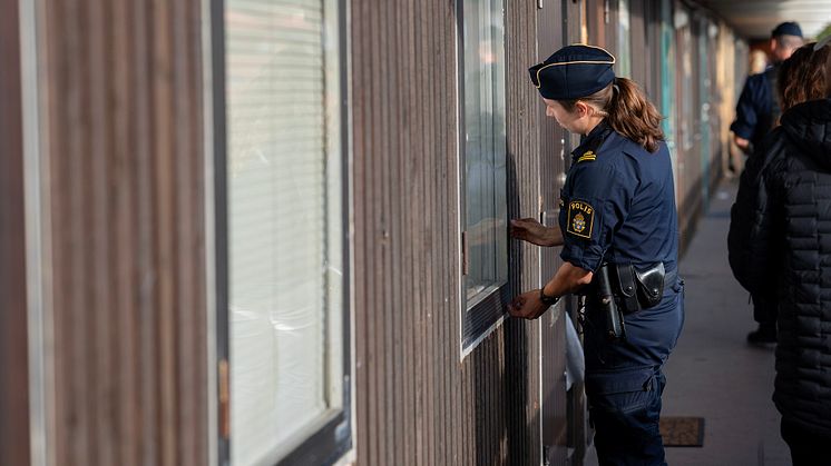 Polisman undersöker fasaden på Hantverkaregatan.