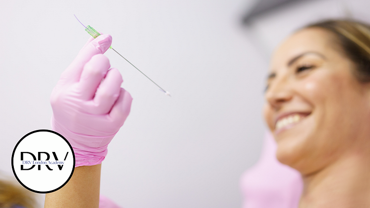 Practitioner wearing pink gloves holding a PDO thread for treatment, with a smiling patient in the background at a London aes