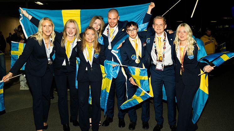 De svenska guld-, silver-, bronsmedaljörerna i Yrkes-EM 2025 med svenska flaggor i händerna och medaljerna runt halsen.