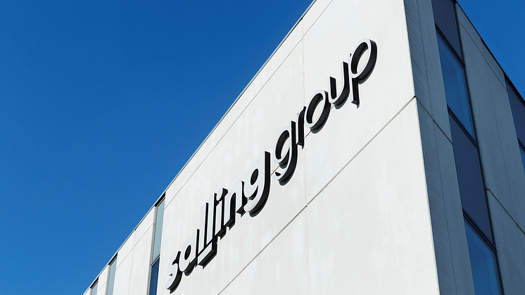 Lysgrå facade med Salling Group-logo mod klarblå himmel.