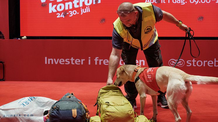 I samarbeid med Storebrand, kontrollerer Tor Iljar fra Dogpoint og labradoren Miss kofferter på Oslo lufthavn denne uken. Foto: Storebrand