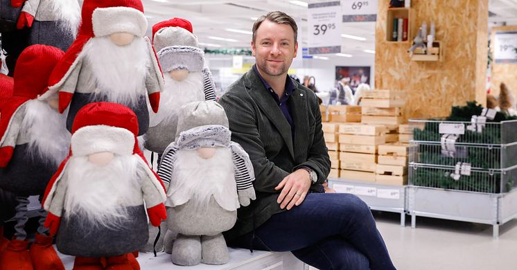 Gekås Ullareds vd, Patrik Levin, sitter på Jultorget omgiven av juldekorationer och tomtar.