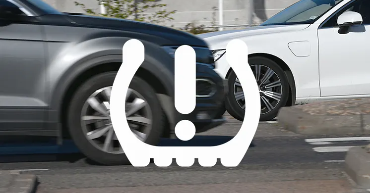 Två bilar som möts samt en symbol över bilden som varnar för för lågt däcktryck.