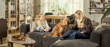 Frau, Kind und Hund auf Sofa