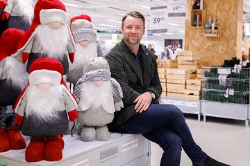 Gekås Ullareds vd, Patrik Levin, sitter på Jultorget omgiven av juldekorationer och tomtar.