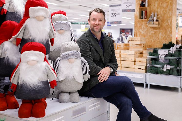 Gekås Ullareds vd, Patrik Levin, sitter på Jultorget omgiven av juldekorationer och tomtar.