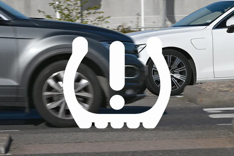 Två bilar som möts samt en symbol över bilden som varnar för för lågt däcktryck.