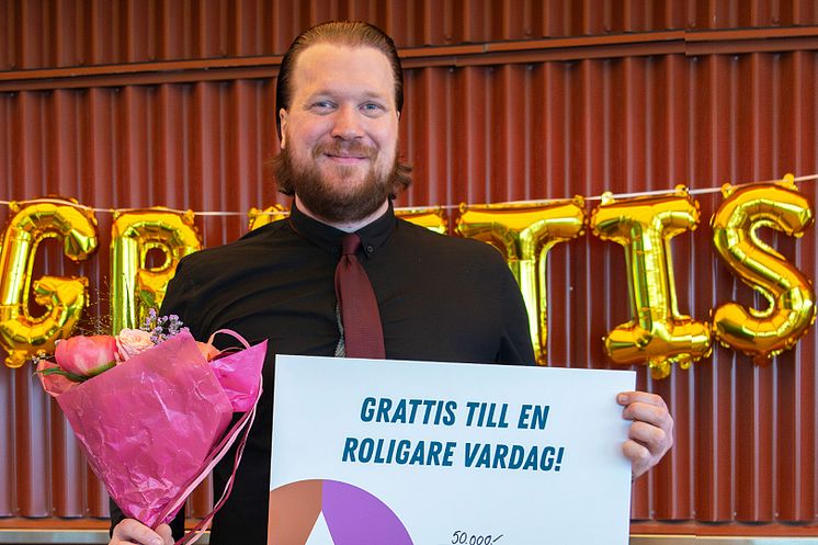 Marcus håller upp bingovinsten på 50 000 kr.