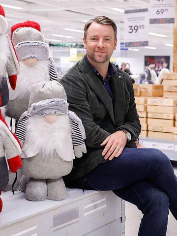 Gekås Ullareds vd, Patrik Levin, sitter på Jultorget omgiven av juldekorationer och tomtar.